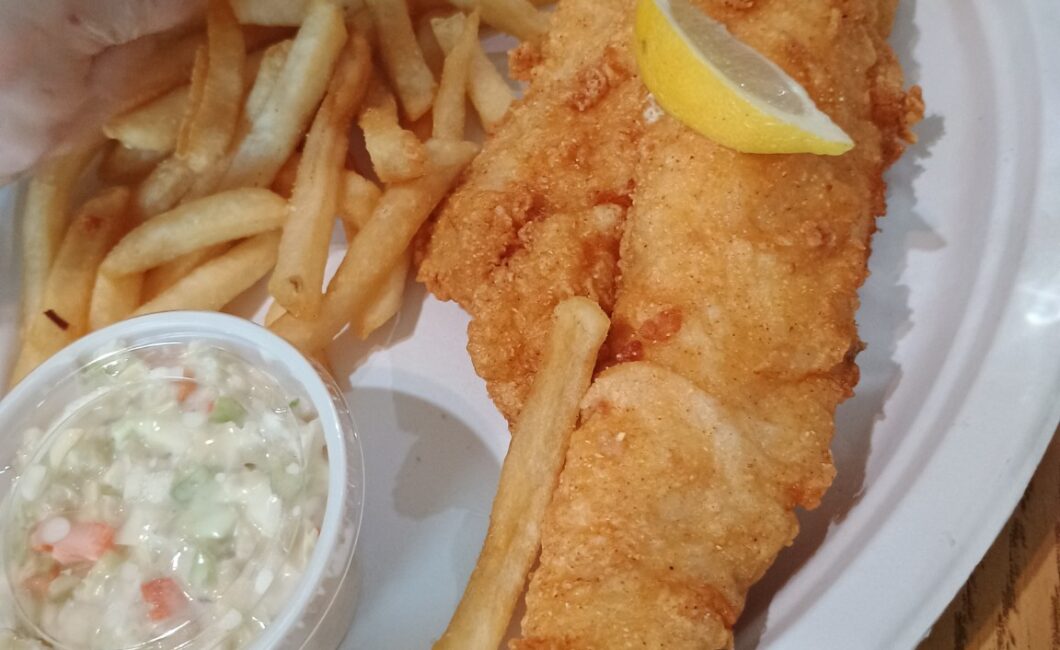 Fried haddock fillet with fries, coleslaw and a wedge of lemon