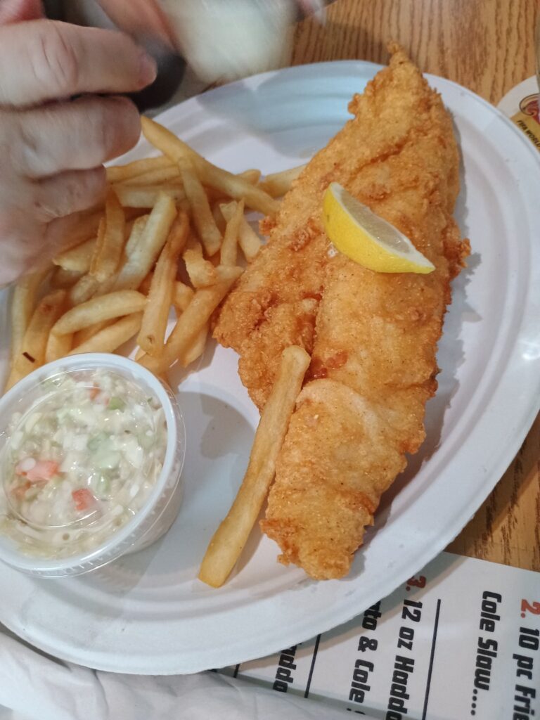 Fried haddock fillet with fries, coleslaw and a wedge of lemon