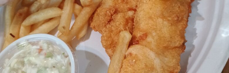 Fried haddock fillet with fries, coleslaw and a wedge of lemon