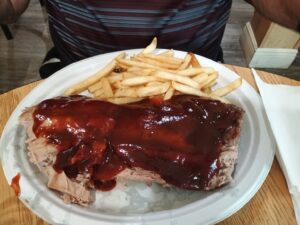 Large sauced portion of ribs with a side of fries