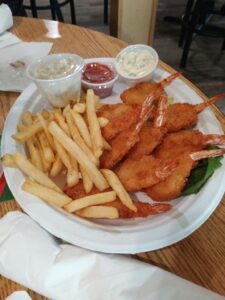 Fried shrimp platter with tails, fries and dipping sauces