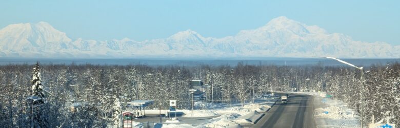 Looking down the snow-covered road through Willow, Alaska, with Denali rising in the distance